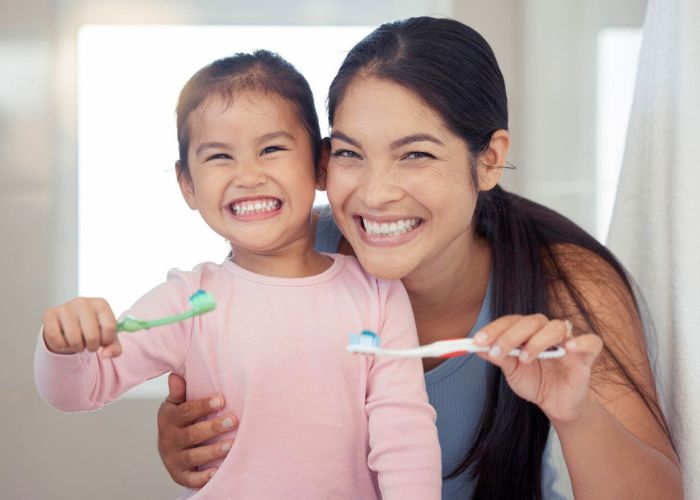 Mom and child brushing teeth 